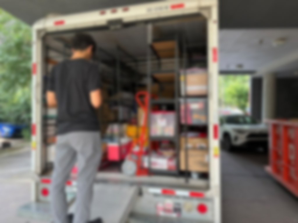 Mover organizing boxes on shelves in the back of a moving truck