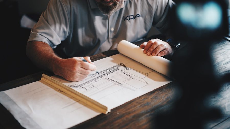 Contractor marking up building plans at a desk
