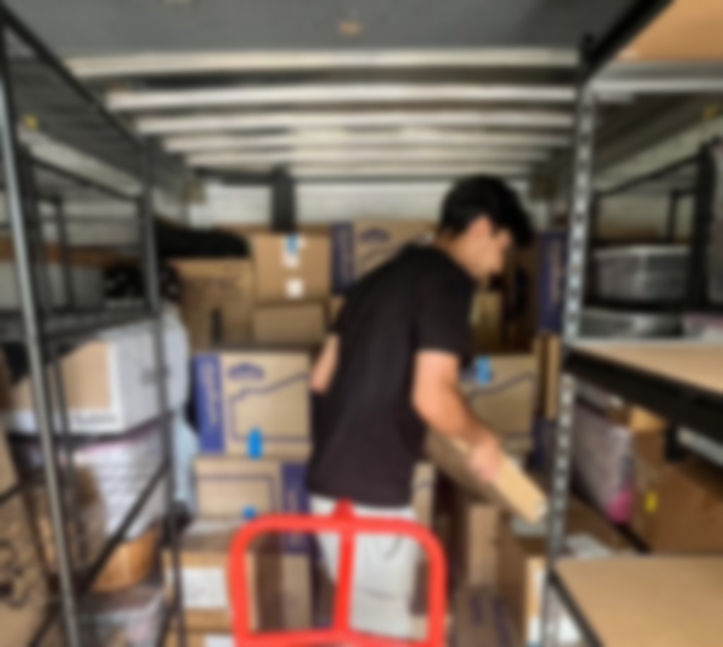 Mover placing a box in a fully packed moving truck